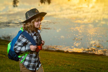 Happy child playing with binoculars. Explore and adventure. Child boy with backpacks exploring...