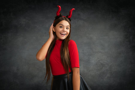 Girl with devil horns. Halloween witch girl. Little kid witch. Kid girl witch celebrates Halloween....