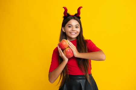 Child teen girl having fun on Halloween. Funny little girl with pumpkin isolated on yellow. Halloween witch girl. Cute teen witch. Happy Halloween. Portrait of an Halloween child.の写真素材