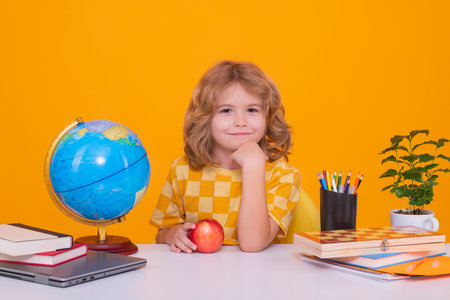 Kid boy from elementary school with book on yellow isolated background. Little student, smart nerd pupil ready to study. Concept of education and learning.の写真素材