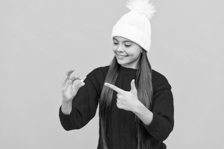 happy teen girl wear hat pointing finger on multivitaminsの写真素材