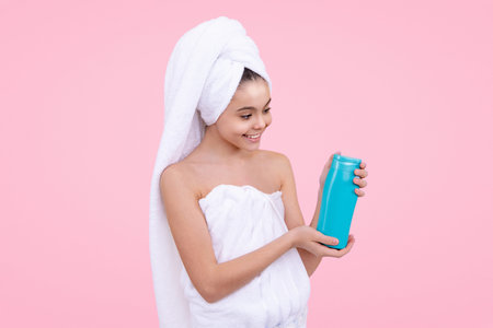 Happy girl with Shampoo bottle. Healthy hair with shampoo. Teen haircare. Shower routine for teenager. Hair gel and shampoo for teen girl. Shampoo for silky hair. Cosmetics product for teenagers.の写真素材