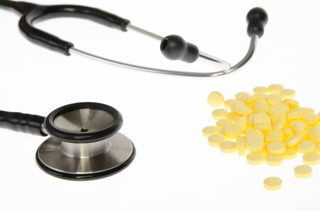Stethoscope and medical pills tablets on white background.の写真素材