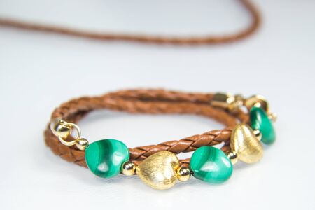 Leather bracelet with brown leather cord and green and gold heart beadsの写真素材