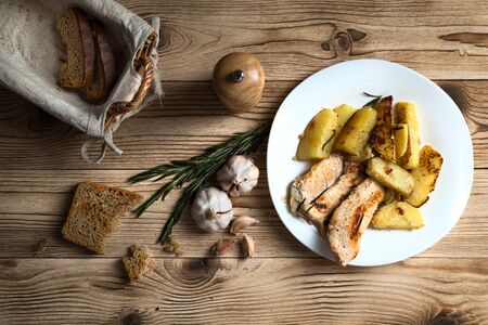 fried potatoes with chicken fillet on a wooden backgroundの写真素材
