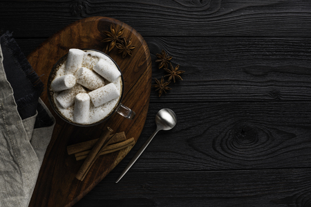 coffee with milk and marshmallow with cinnamon and anise on wooden background top viewの写真素材
