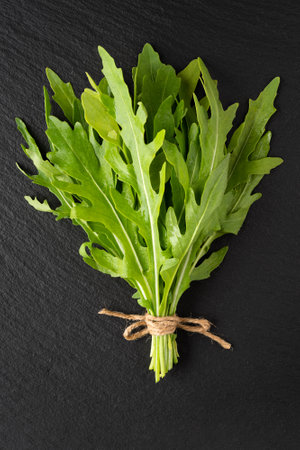 a bunch of fresh arugula on slateの写真素材