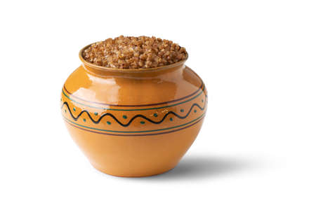 buckwheat porridge cooked in a clay pot isolated on white background
