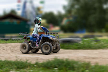 a child rides an ATV on the trackの写真素材