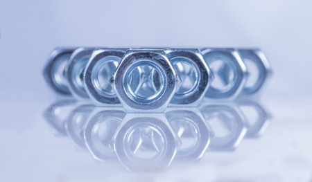 steel chromeplated nuts on reflecting surfaceの写真素材