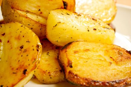 roasted potatoes with seasoning on plate, close upの写真素材