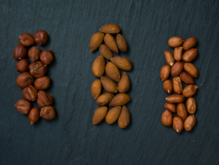 assorted  mixed nuts on a black stone table, flat lay  with copy spaceの写真素材