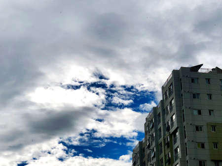 a building and the blue sky overshadowed by cloudsの写真素材