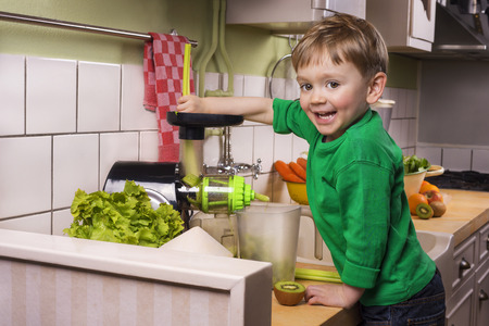 Happy toddler making green juiceの写真素材