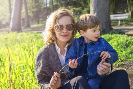 mother and son sitting in a city parkの写真素材