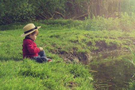 cute little boy playing by the pondの写真素材