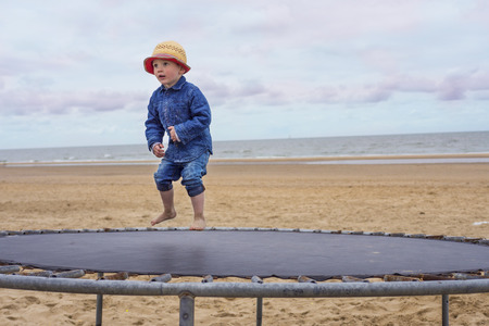 little boy jumping on a trampolineの写真素材