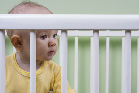baby sitting in a cribの写真素材
