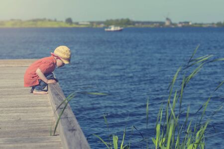 cute toddler playing by the lakeの写真素材