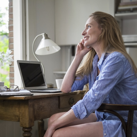 Woman having a morning phonecall in her home office