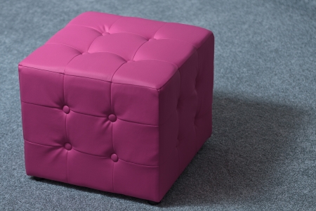 Leather pink footstool isolated on grey carpetの写真素材