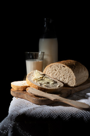 Bottle of milk, and bread on the wooden table. on the black bogroundの写真素材