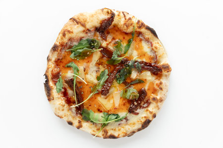 Thai pizza VEGAN with vegan cheese, sun-dried tomato, pineapple, sweet chilli sauce on white background. Pizza top view.の写真素材