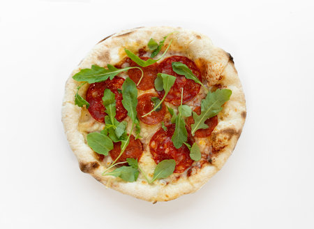 Pizza with mozzarella cheese, pepperoni, salami, dried basil, arugula isolated on white background. Pizza top view.の写真素材