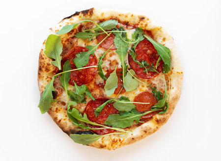 USA pizza with mozzarella cheese, pepperoni, salami, dried basil, arugula isolated on white background. Pizza top view.の写真素材