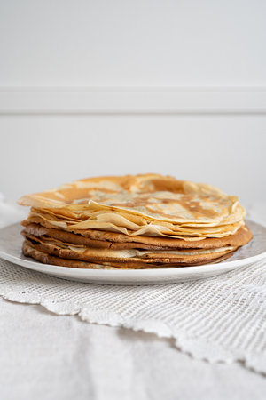 Hommemade pancakes on a white plate.