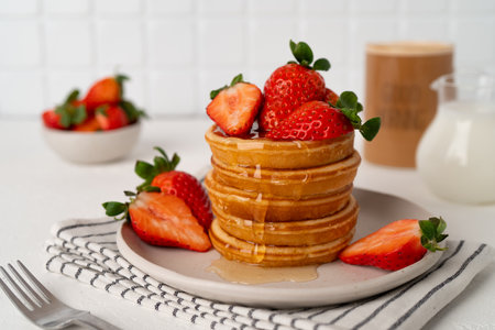 Tasty pancakes with fresh strawberry and sweet honey on plate. Healthy breakfastsの写真素材