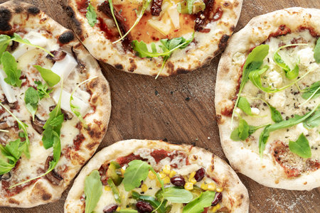 4 pizzas on wooden background.Isolated on white background. Pizza top view. Pizza top view.