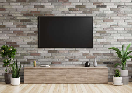 TV in the living room on a brick wall with wooden cabinets and plant pots on the floor.3d renderingの写真素材