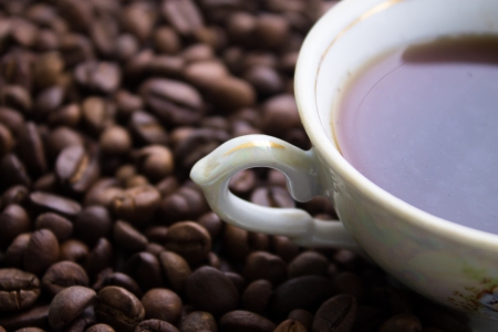 White cup of black coffee on coffee beans backgroundの写真素材