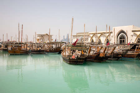 View on wooden ships and Dhow Harbour building in Doha City, Qatarのeditorial素材
