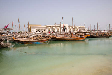 View on wooden ships and Dhow Harbour building in Doha City, Qatarのeditorial素材