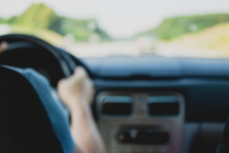Defocused car interior, hands on wheel and road view backgroundの写真素材