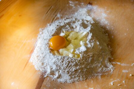 Wheat flour with egg and butter on brownの写真素材