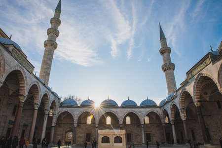 Istanbul, Turkey - December 2018: View on Suleymaniye Mosque with people inside yard with beautiful sun light and minarets on blue skyのeditorial素材