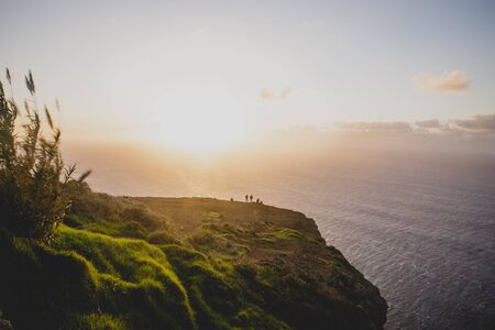 Beautiful scenic sunset view on cliffs coast of Atlantic Ocean with blue breaking waves in Madeira islandの写真素材