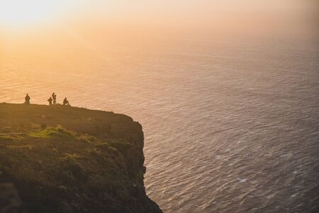 Beautiful scenic sunset view on cliffs coast of Atlantic Ocean with blue breaking waves in Madeira islandの写真素材