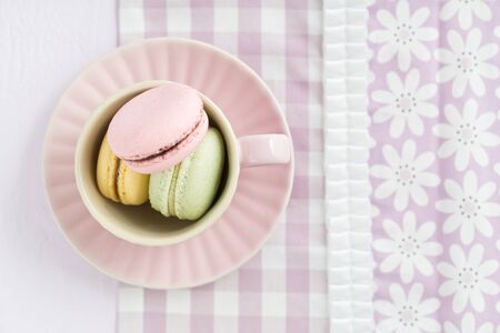 Colourful macarons in a rosy cupの写真素材