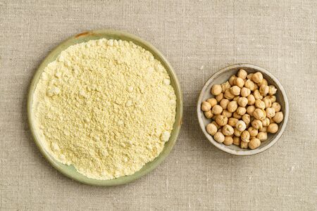 Chickpea seeds and chickpea flour in small bowlsの写真素材