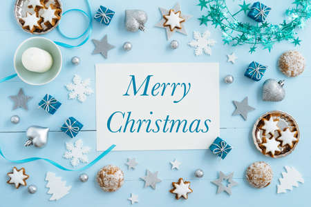 Christmas background, mockup, postcard or website header design with the words Merry Christmas on blue wooden table