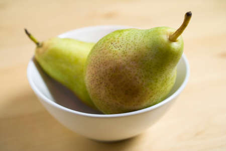 Two pears in a white porcelain bowlの写真素材