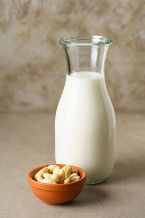 Fresh homemade cashew milk in a bottle with fresh cashewsの写真素材