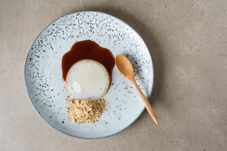 Food trend raindrop cake made from mineral water and agar agar served with roasted soy flour and sugar cane syrup on plateの写真素材