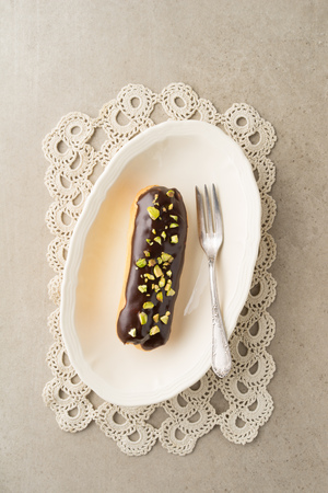 Eclair with chocolate ganache with pistachio toppingの写真素材