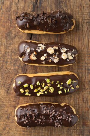 Eclairs with chocolate ganache with different toppings