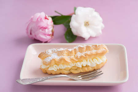 Eclairs with buttercream filling and powdered sugar